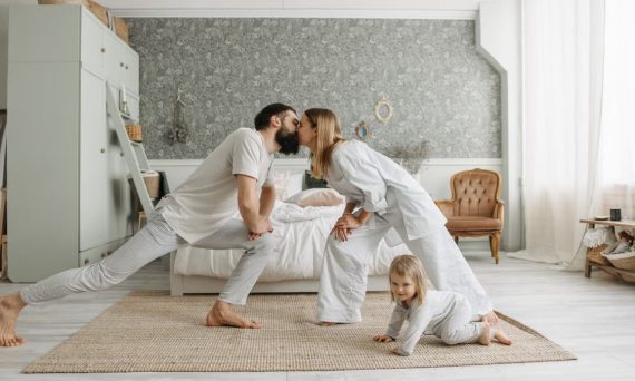A family enjoying playful bonding moments in a stylish, minimalistic bedroom setting.
